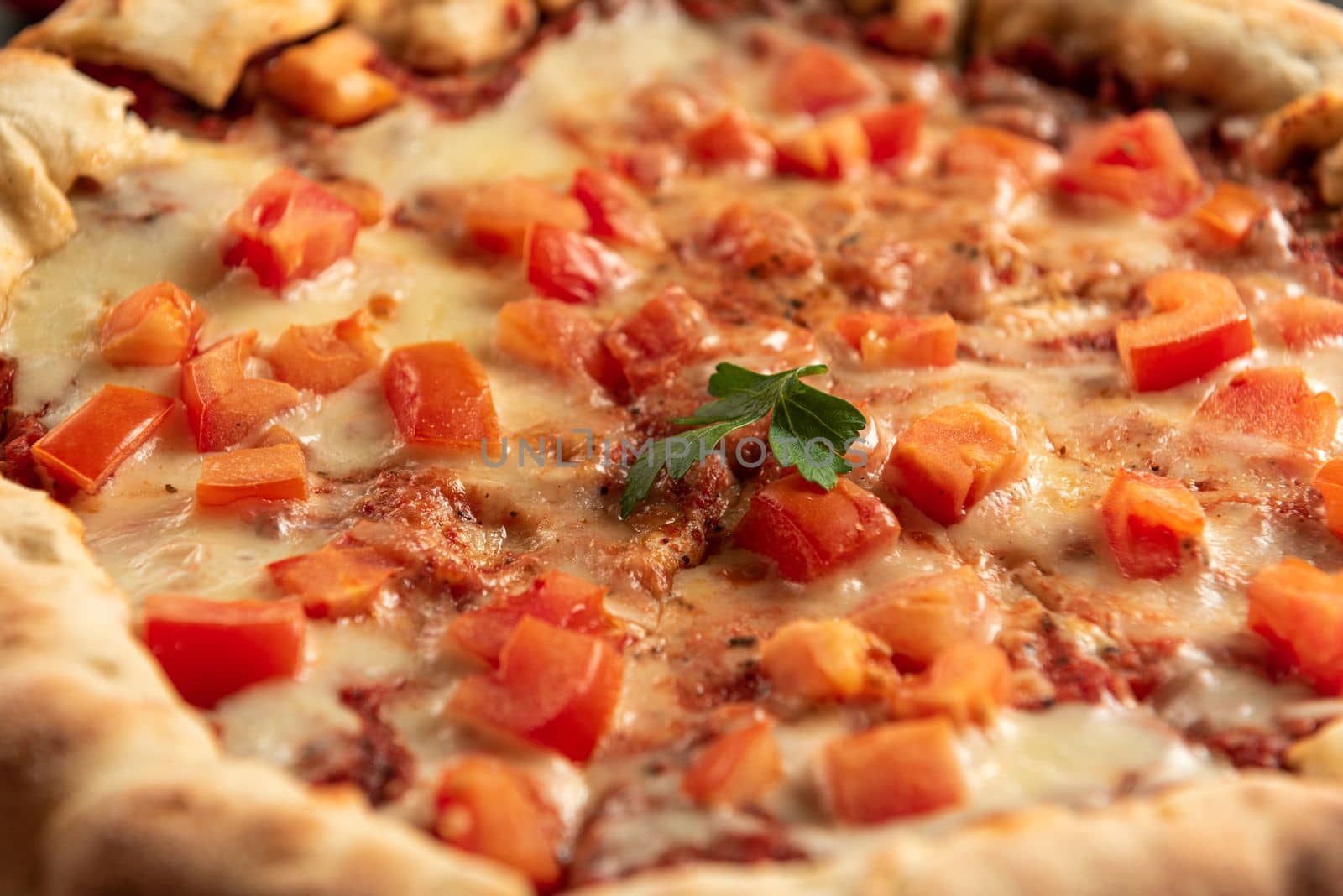 Spicy Indian pizza close up. Indian pizza on a dark background top view. by gulyaevstudio