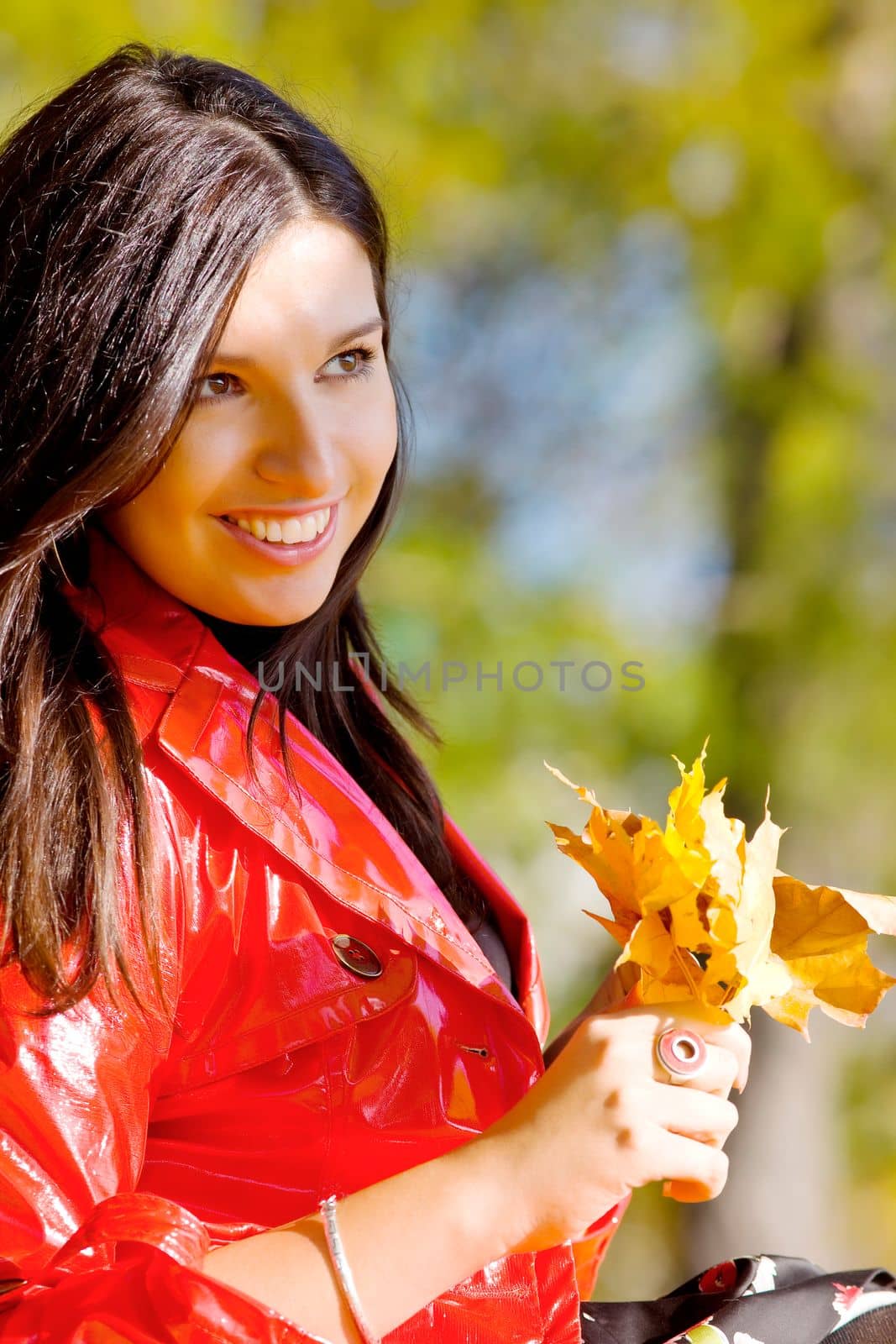 Young woman in autumn park with yellow leaves