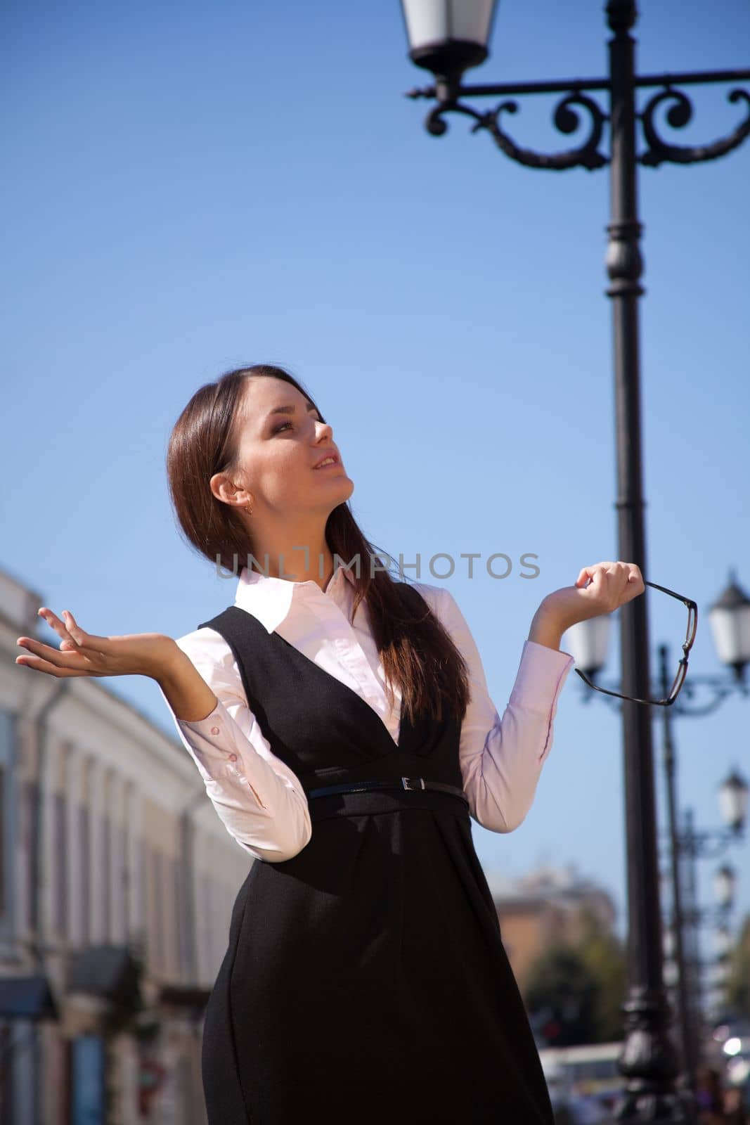 Young happy woman with glasses in old city street