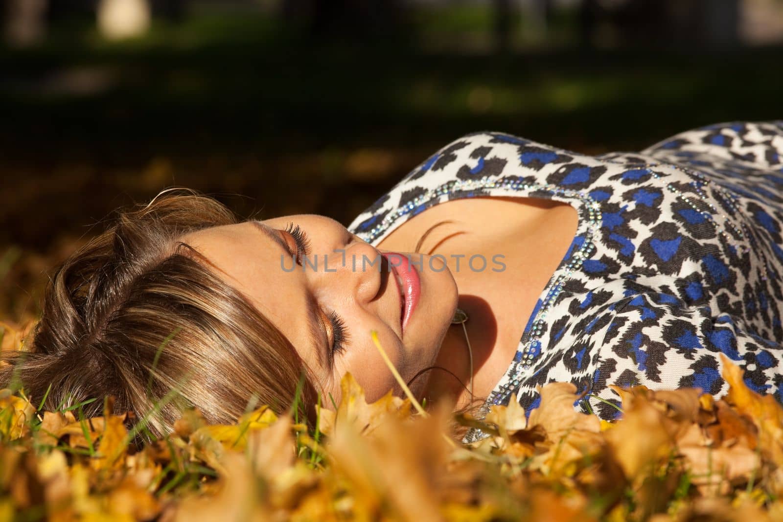 woman lay on ground in autumn leaves