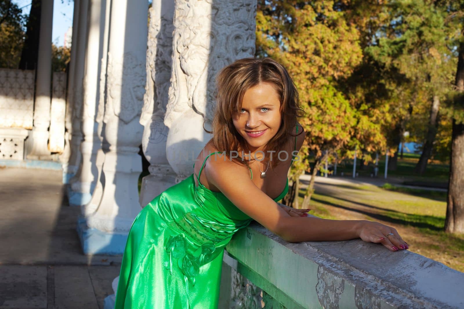 Beauty woman in green clothes smile on autumn sunset
