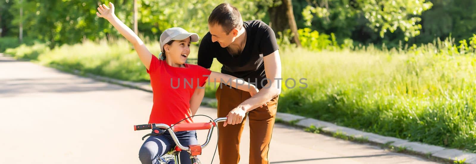 loving father teaching daughter to ride bike by Andelov13