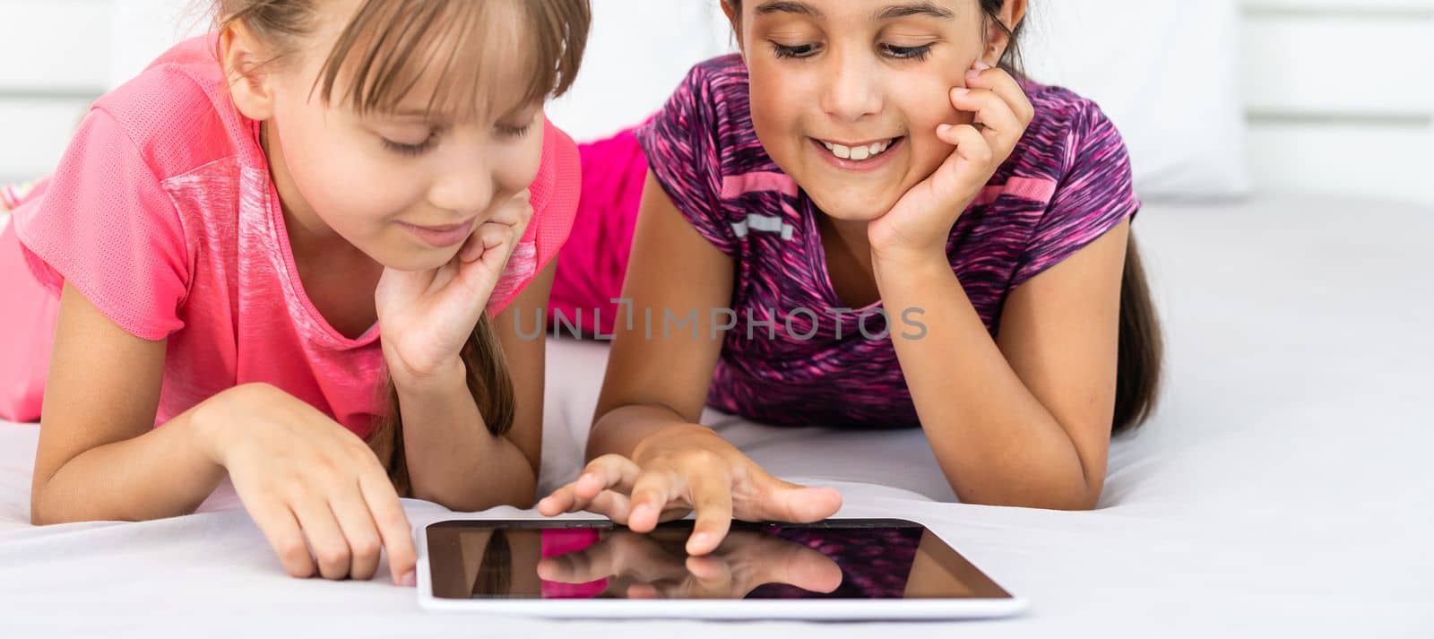Little girls using tablet computer as art board - painting together by Andelov13