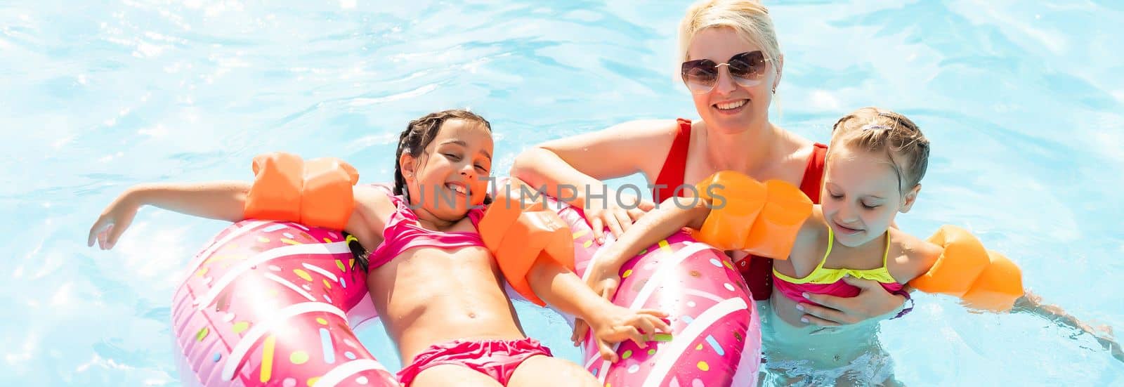 Happy family playing in swimming pool. Summer vacation concept.