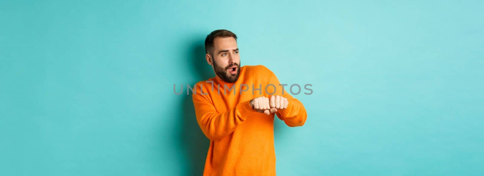Happy young man do champion dance, celebrating victory or success, light blue background.