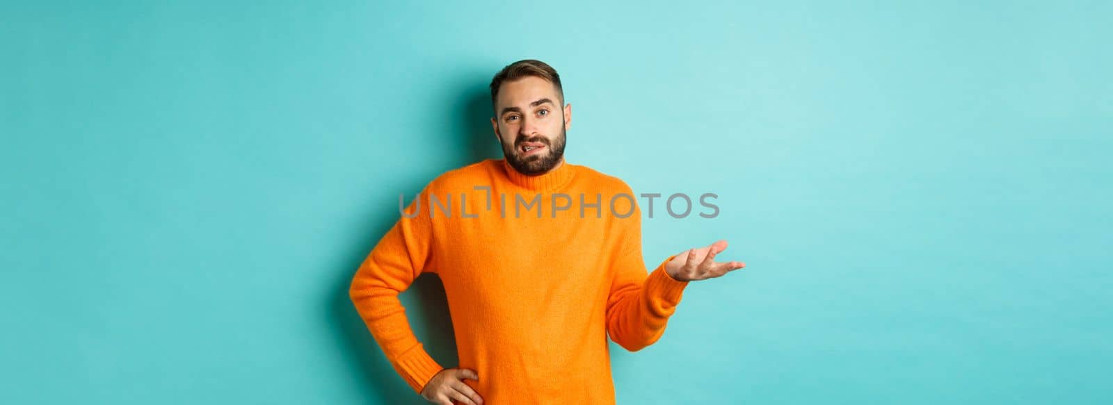 Careless and indifferent guy shrugging, looking unbothered, dont know anything, standing over light blue background.