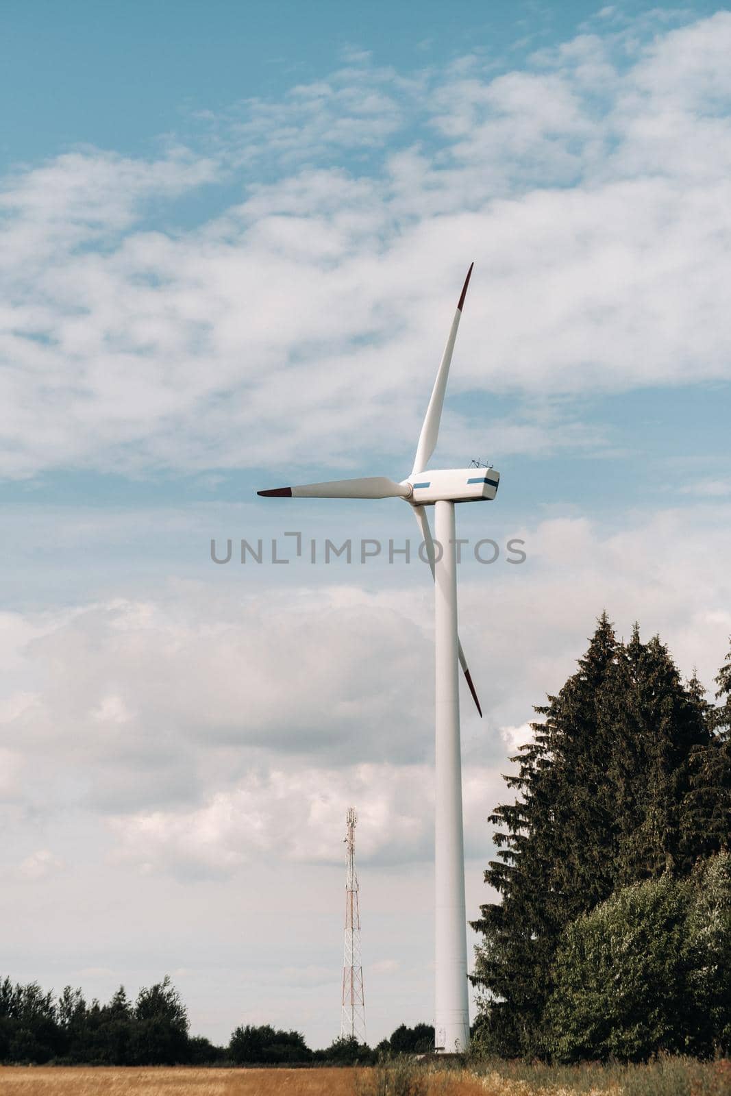 A white Windmill against a blue sky. Windmill in nature.