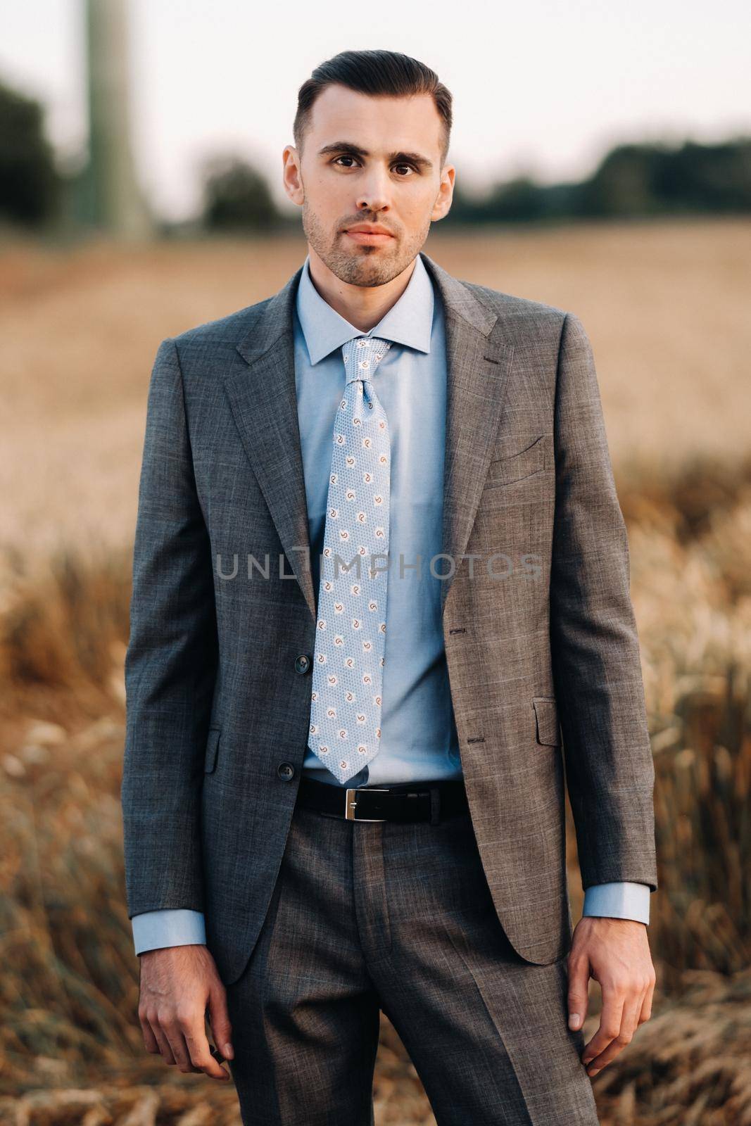 Portrait of a businessman in a gray suit in a wheat field.A man in nature in a jacket and tie.