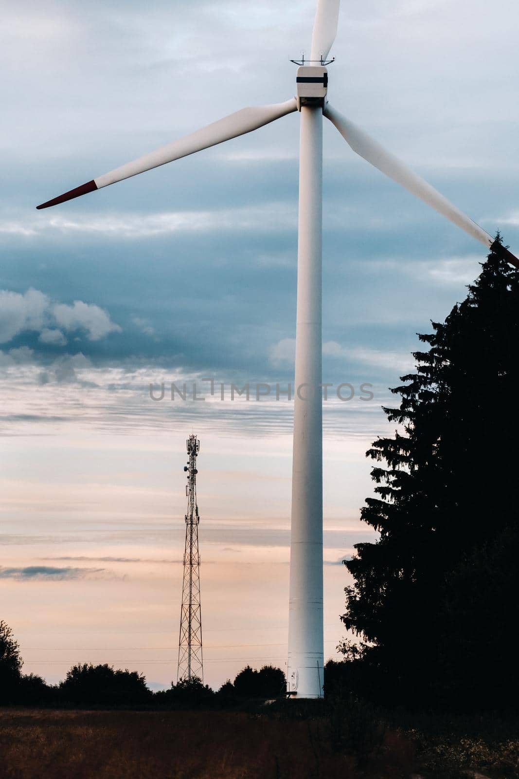 White Windmill against the sunset sky. Windmill in nature.