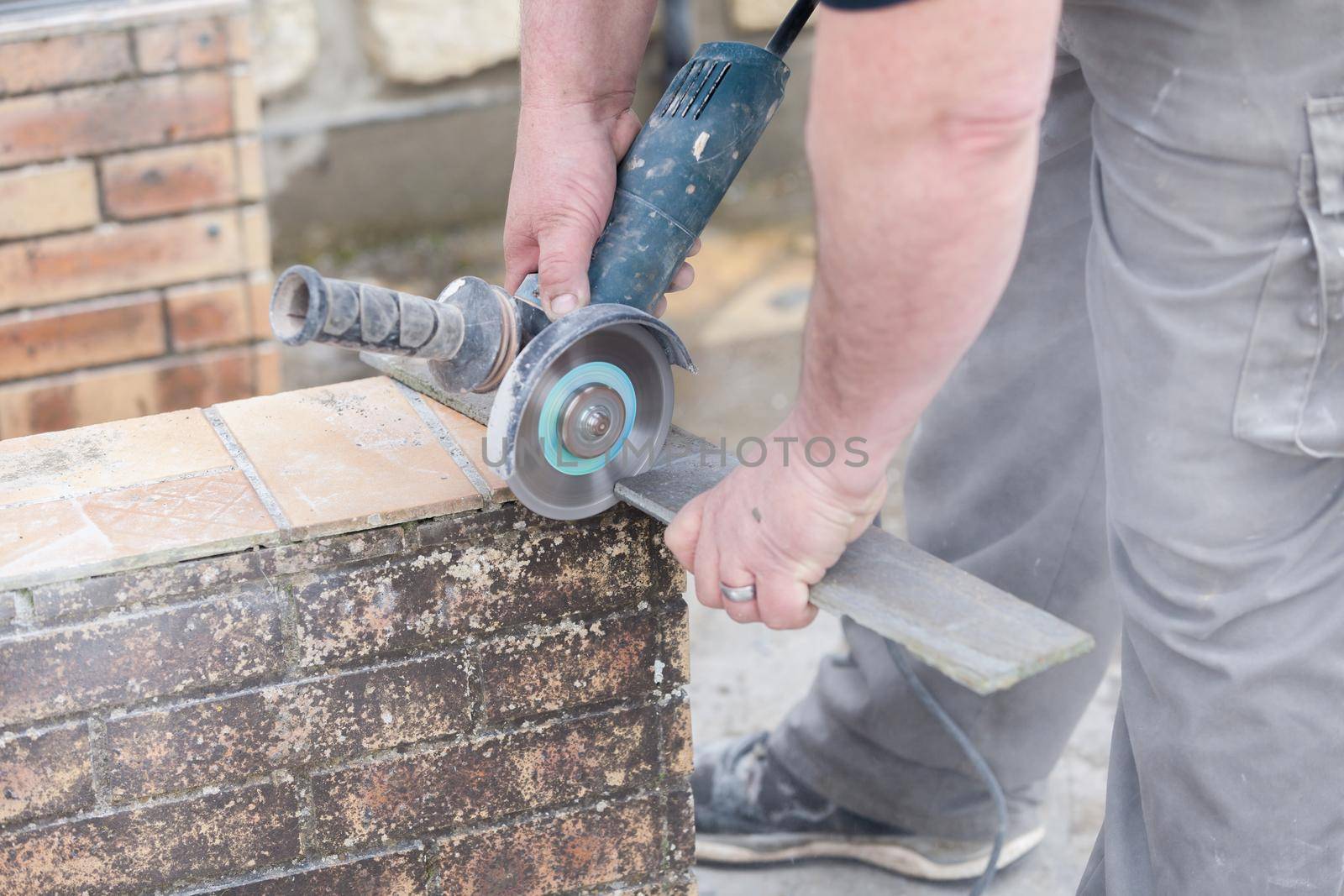 tiler cutting a tile with a grinder