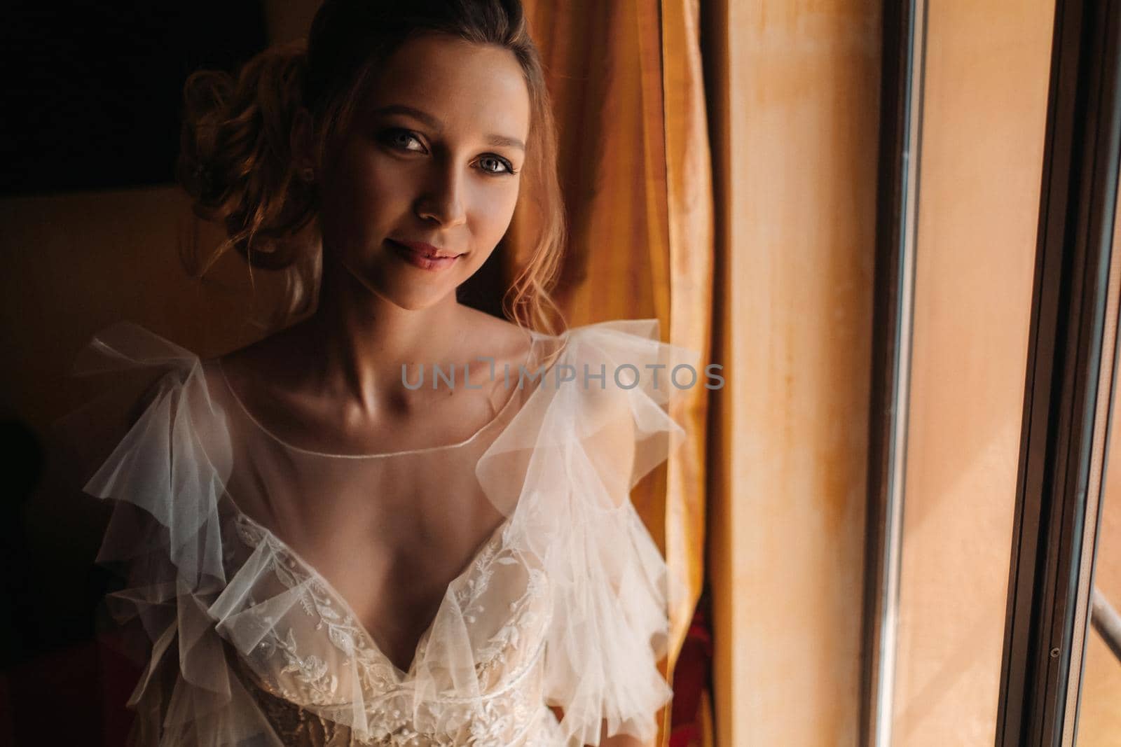 pretty blonde bride with nicea beautiful bride with pleasant features in a wedding dress poses in the interior of the room. Portrait of the bride in Provence. France.