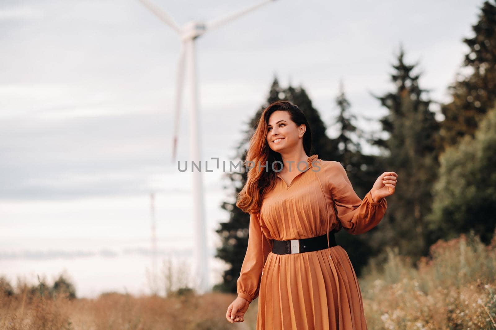 portrait of a Girl in a orange long dress with long hair in nature in the evening. by Lobachad