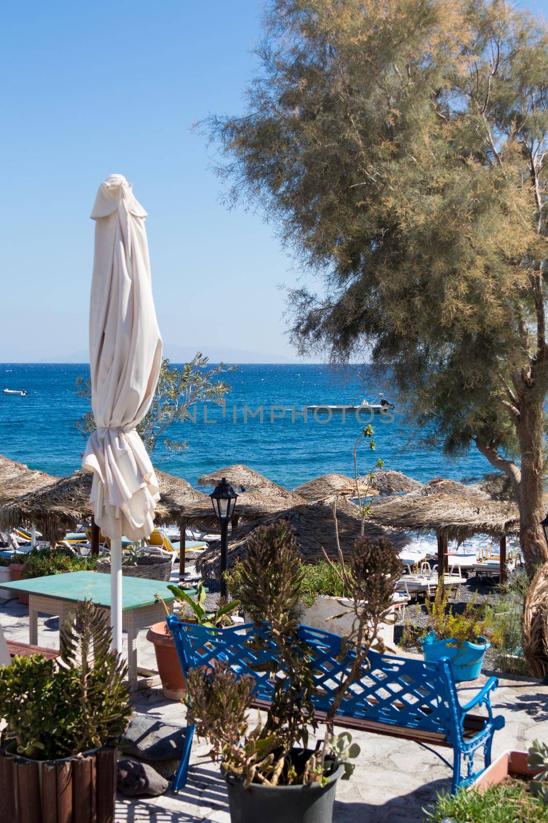 beach with umbrellas and deck chairs in Santorini