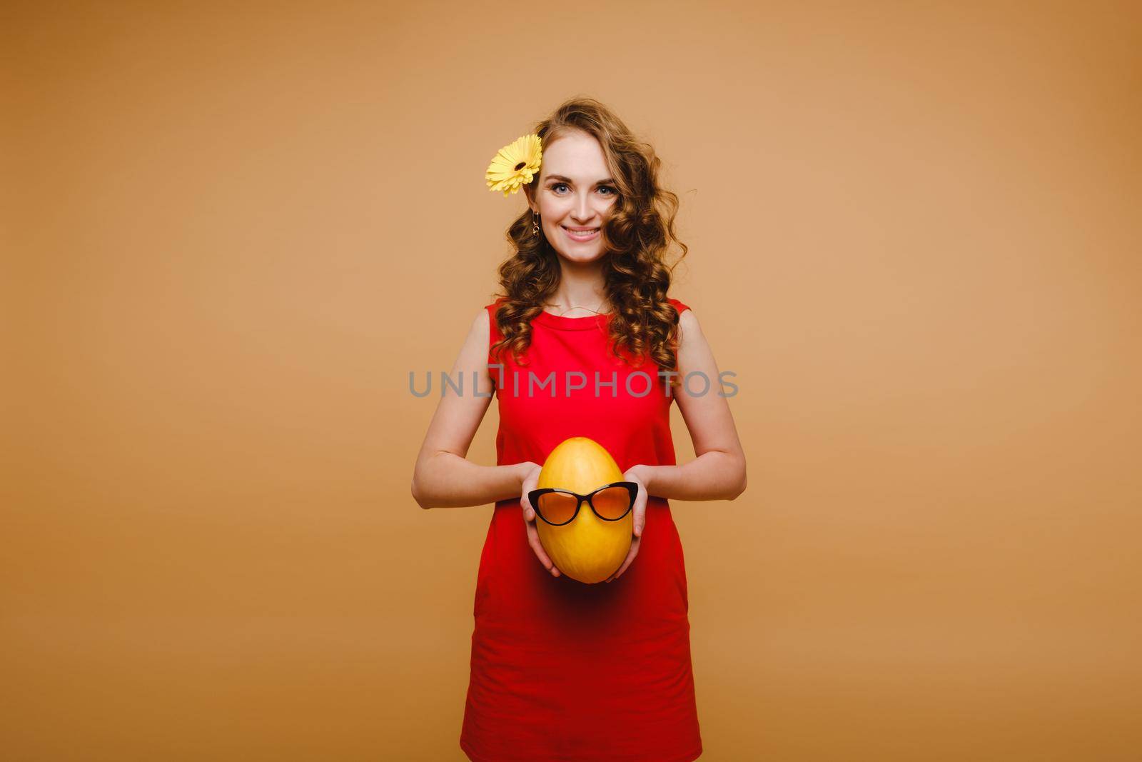 Portrait of a happy young woman holding a melon with glasses. Melon with a smile.