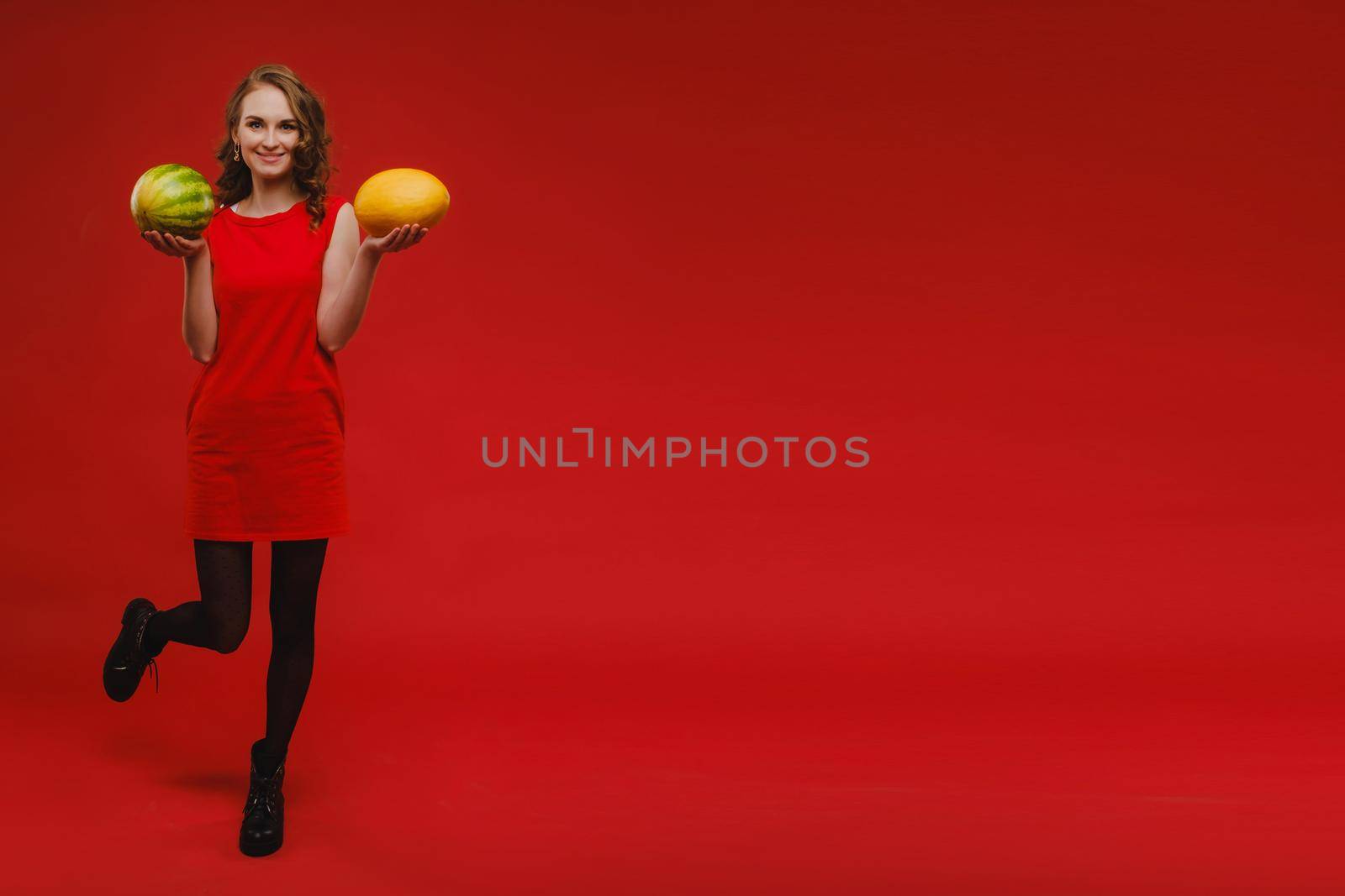 Photo of wavy cheerful curly casual positive cute nice charming pretty girlfriend smiling toothily having fetched you a watermelon isolated over vivid orange color background.