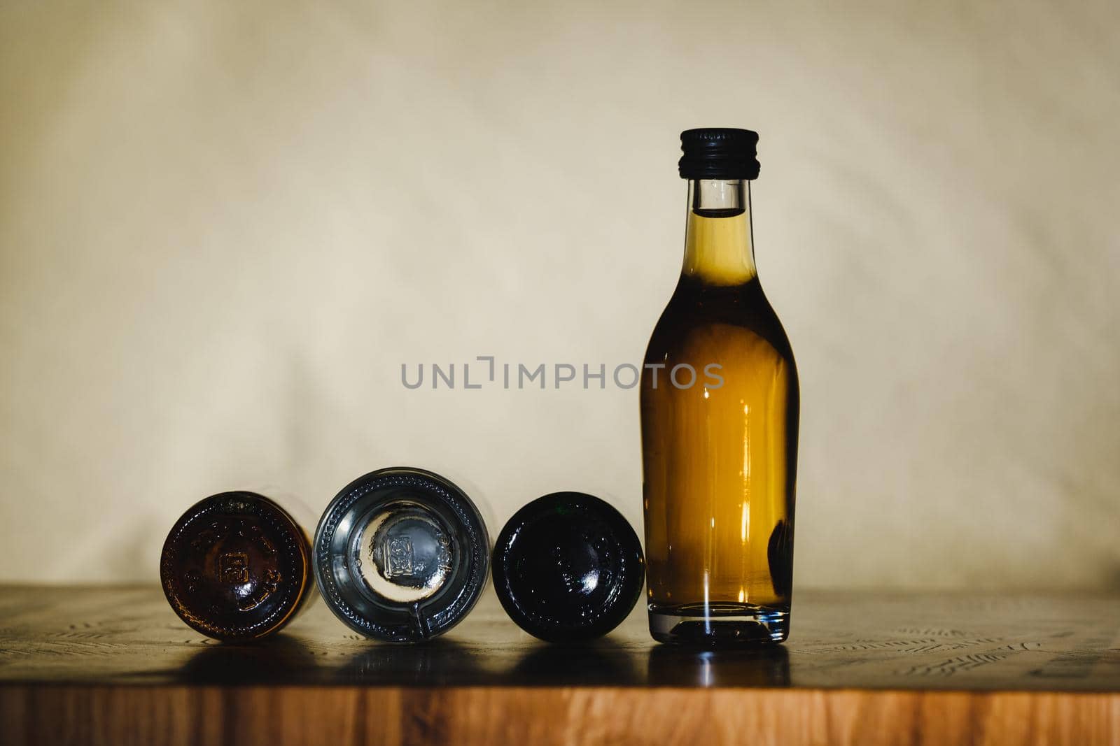 different alcohol bottles are on the table on a light background.