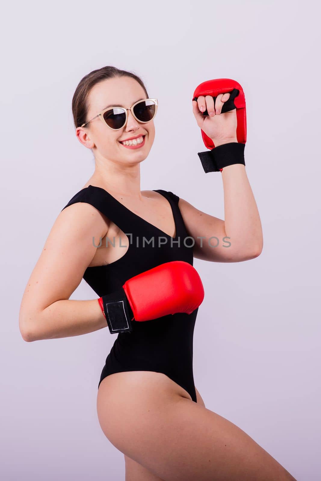 Studio portrait of a boxer female in bodysuit with gloves red