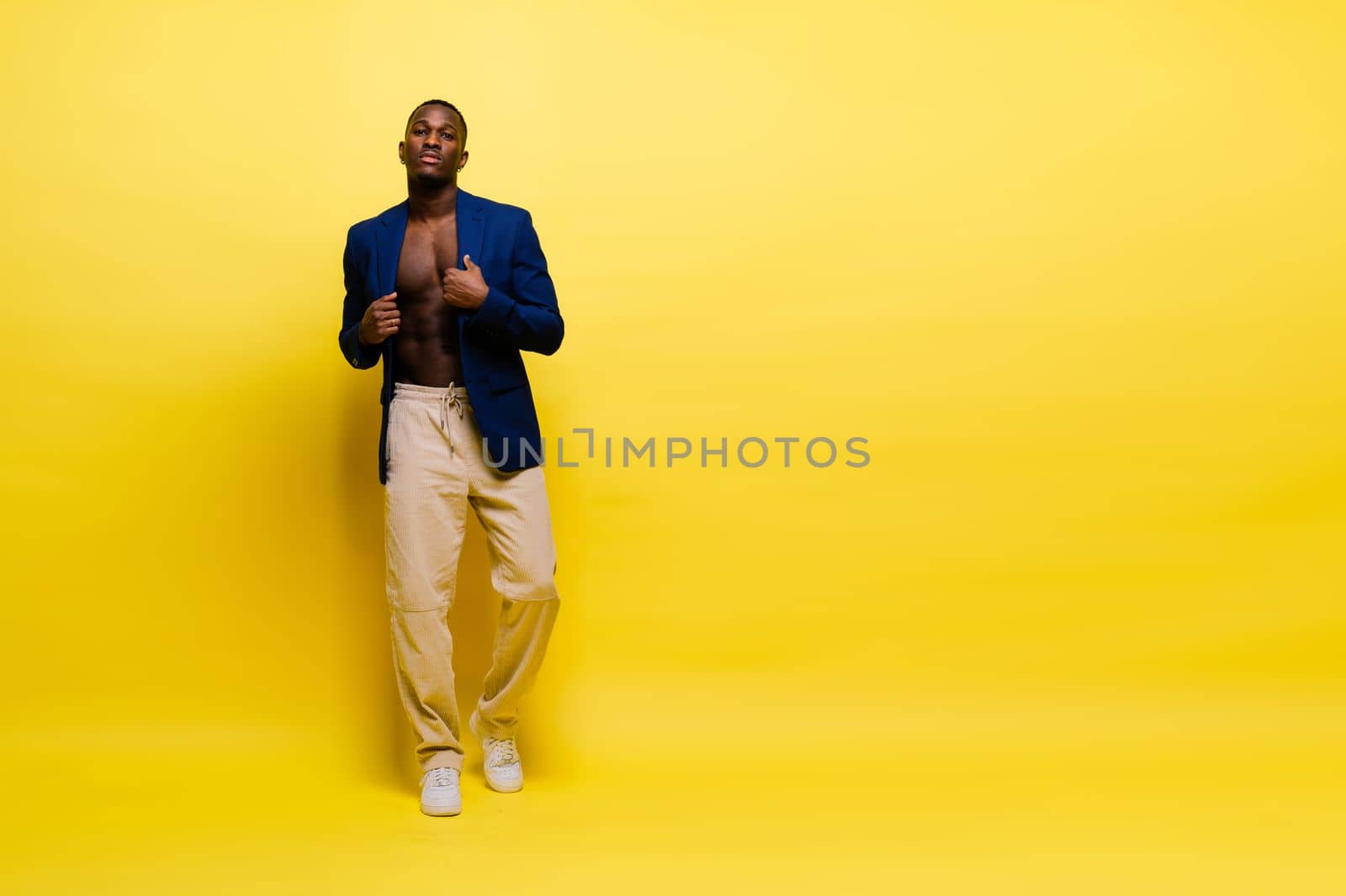 Smiling young african american man guy isolated on yellow background studio. People sincere emotions by Zelenin