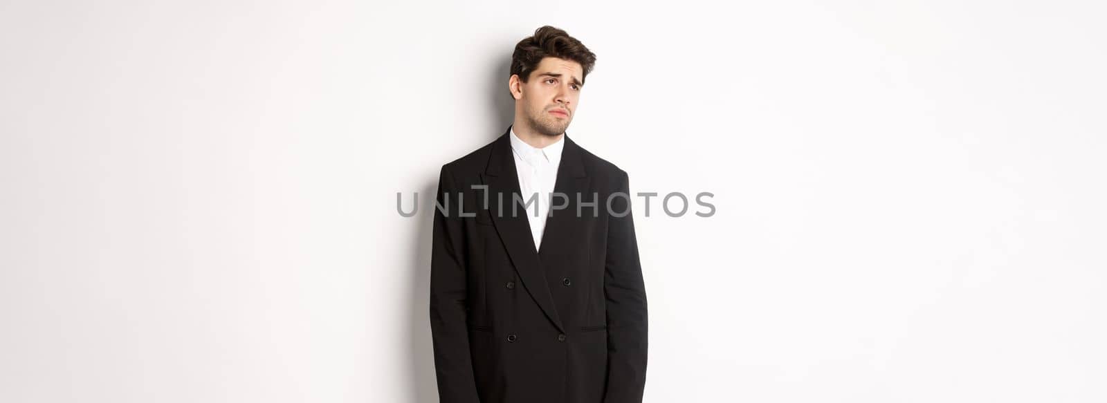 Image of tired man in suit looking left with distressed, gloomy expression, stare left at copy space, standing exhausted over white background by Benzoix