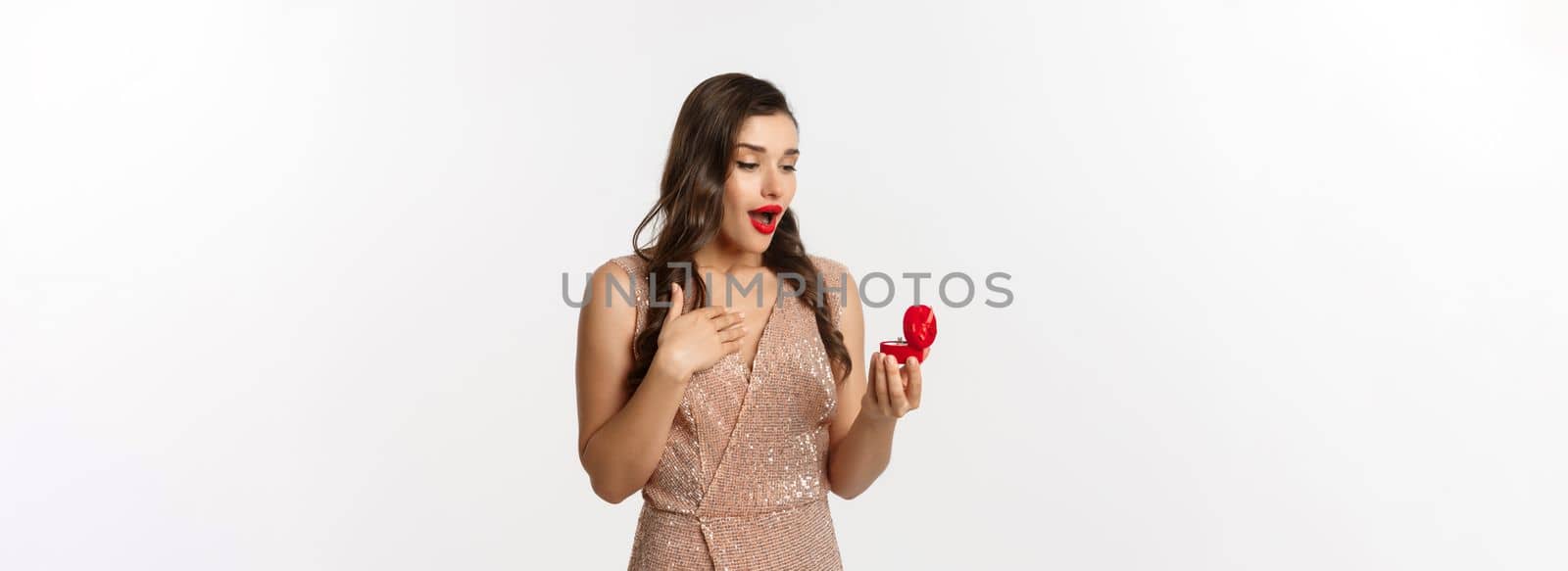 Image of surprised woman receiving marriage proposal, looking at engagement ring in red box and gasping amazed, concept of relationship.