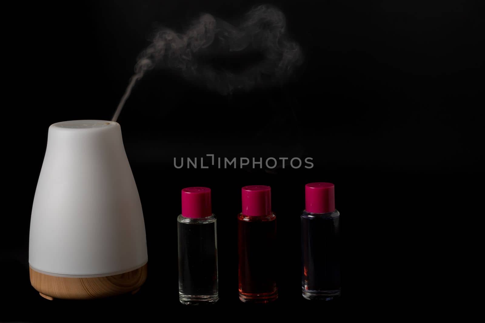 aroma humidifier steaming with scent pots isolated on a black background