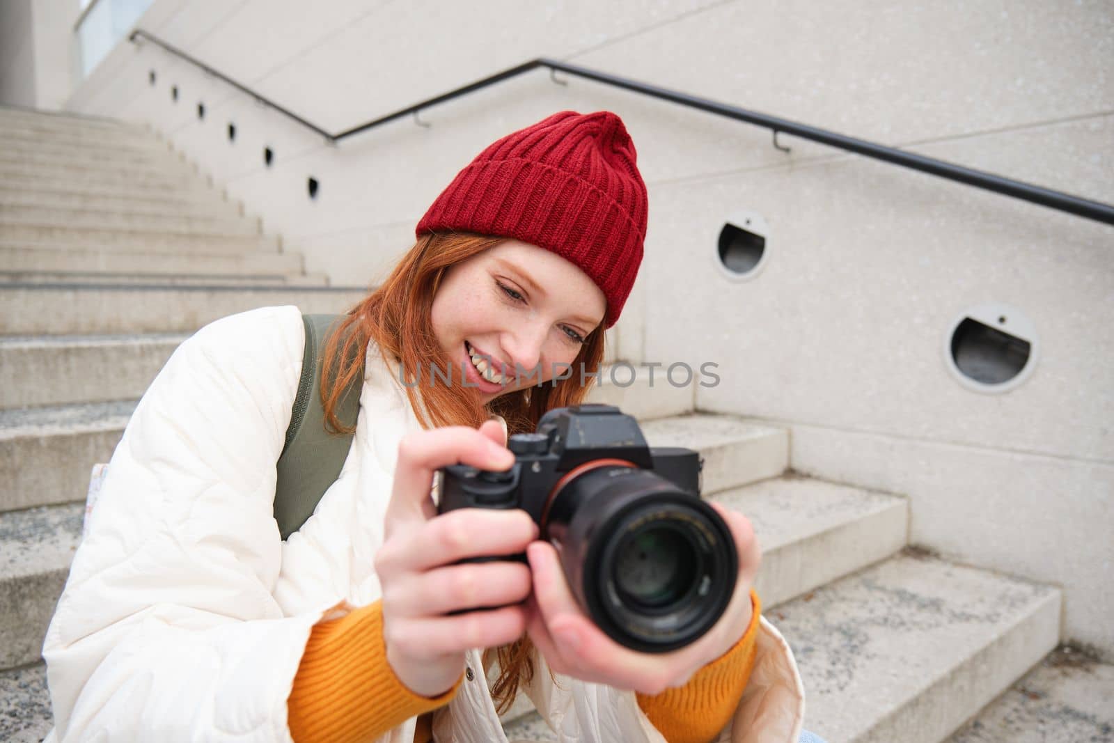 Portrait of female photographer walking around city with professional camera, taking pictures capturing urban shots, photographing outdoors.