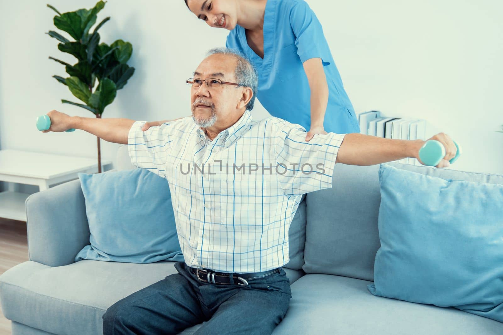 Contented senior patient doing physical therapy with the help of his caregiver. Senior physical therapy, physiotherapy treatment, nursing home for the elderly