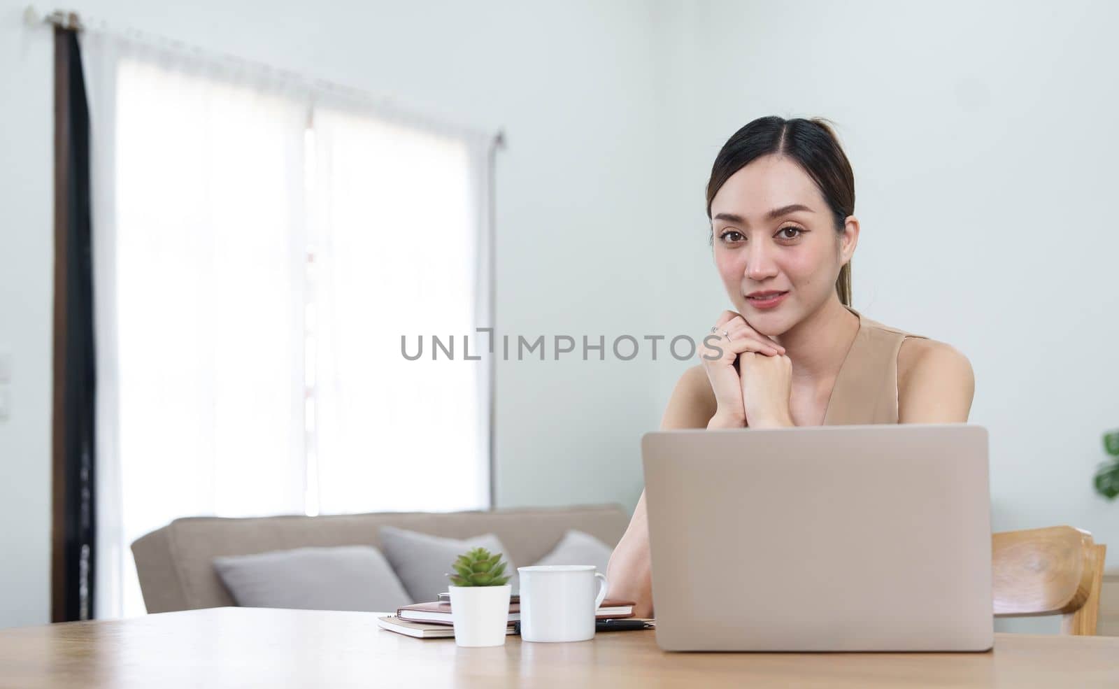 Portrait of Young woman using laptop computer at the office, Student girl working at home. Work or study from home, Asian woman freelance, business, lifestyle concept by wichayada