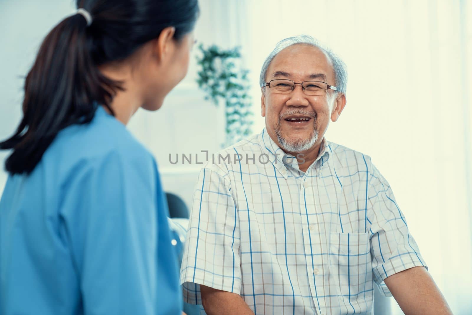 A young female doctor inquires about personal information of a contented senior at home. Medical care for the elderly, elderly illness, and nursing homes, home care.