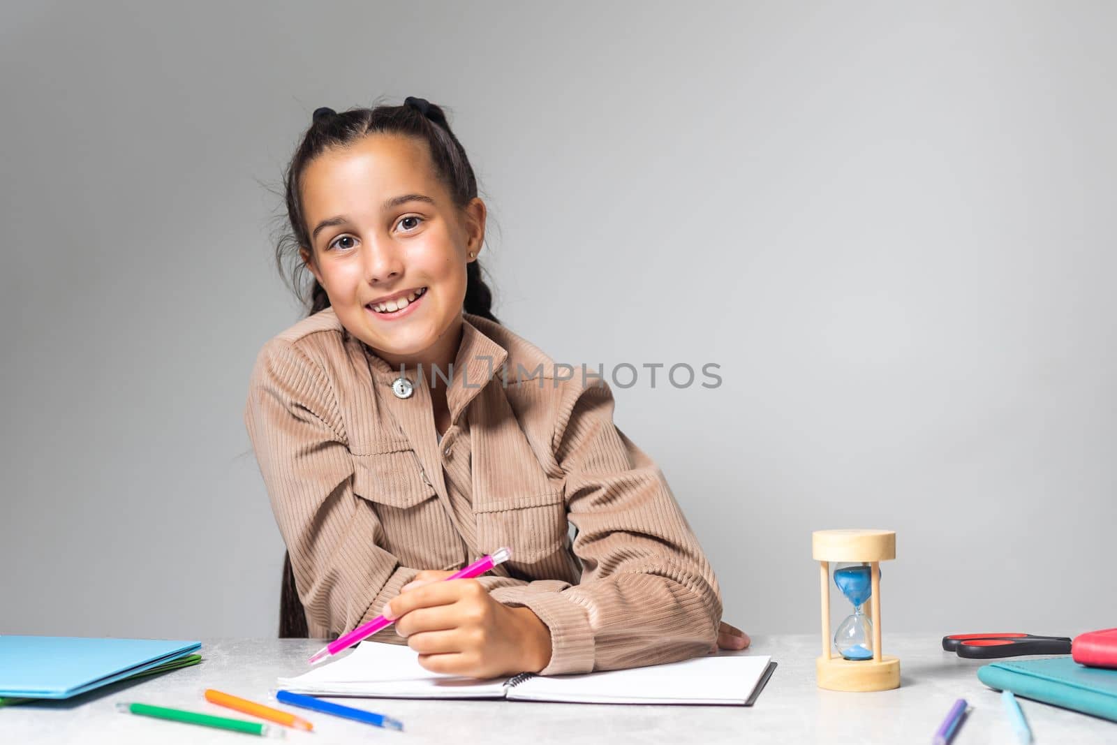 Little Girl doing homework on desk.