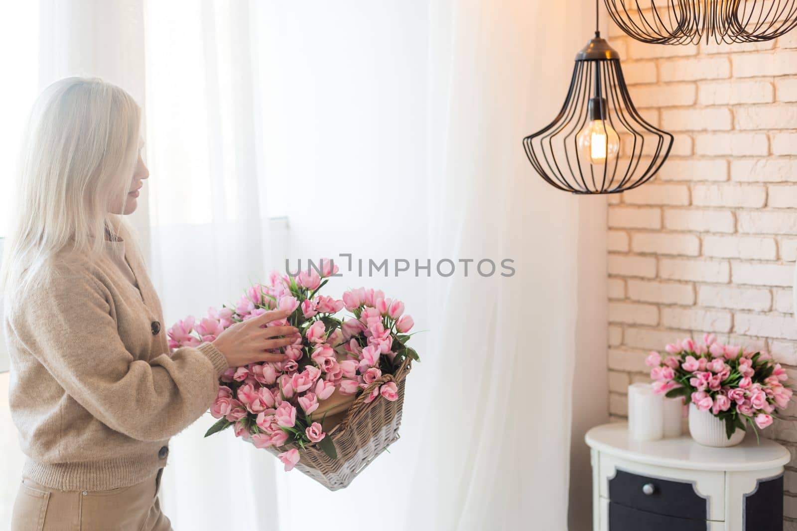 Floral shop concept . Florist woman creates flower arrangement in a wicker basket. Beautiful bouquet of mixed flowers. Handsome fresh bunch. Flowers delivery by Andelov13
