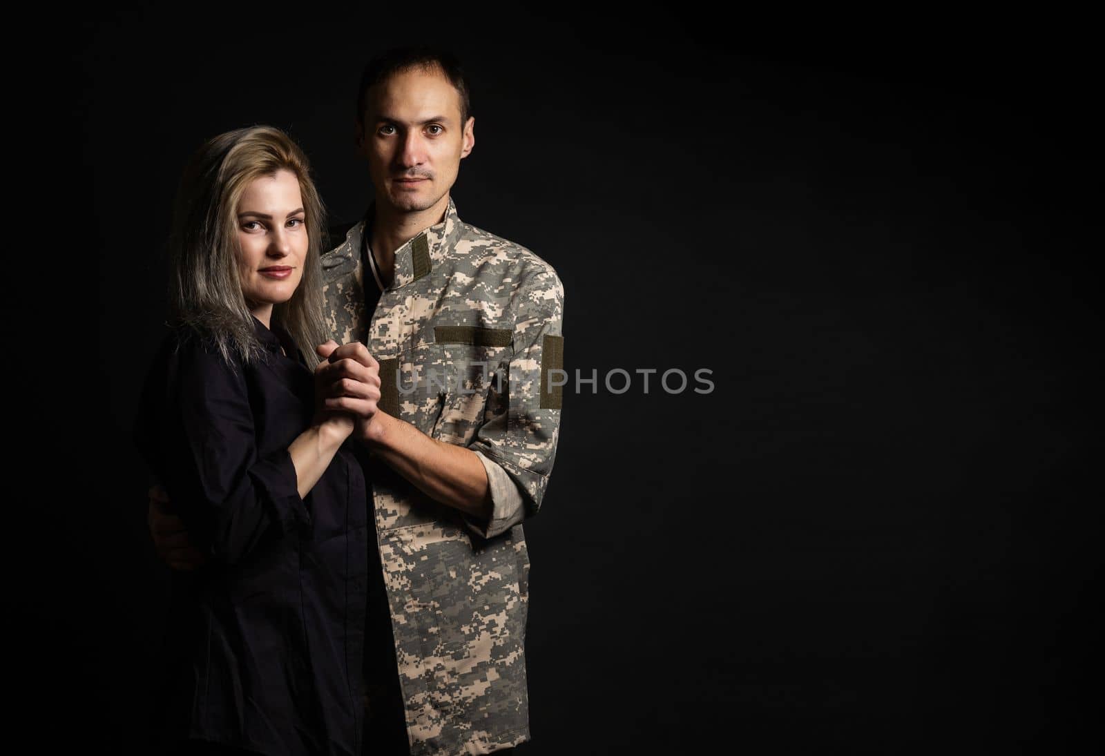 military man and his wife on a black background.