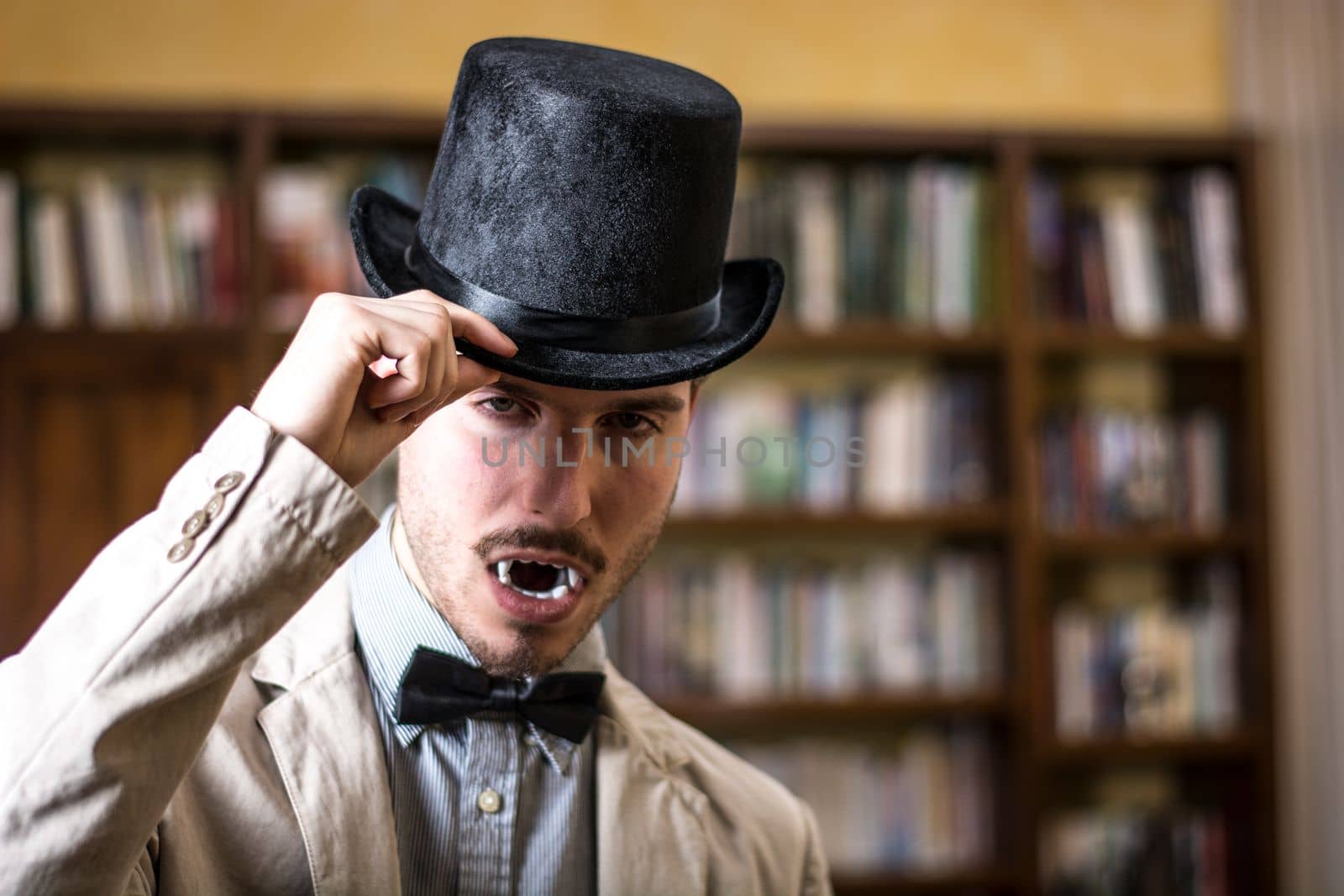 Portrait of a Young Vampire Man with High Hat Looking at the Camera, At Home or in Library