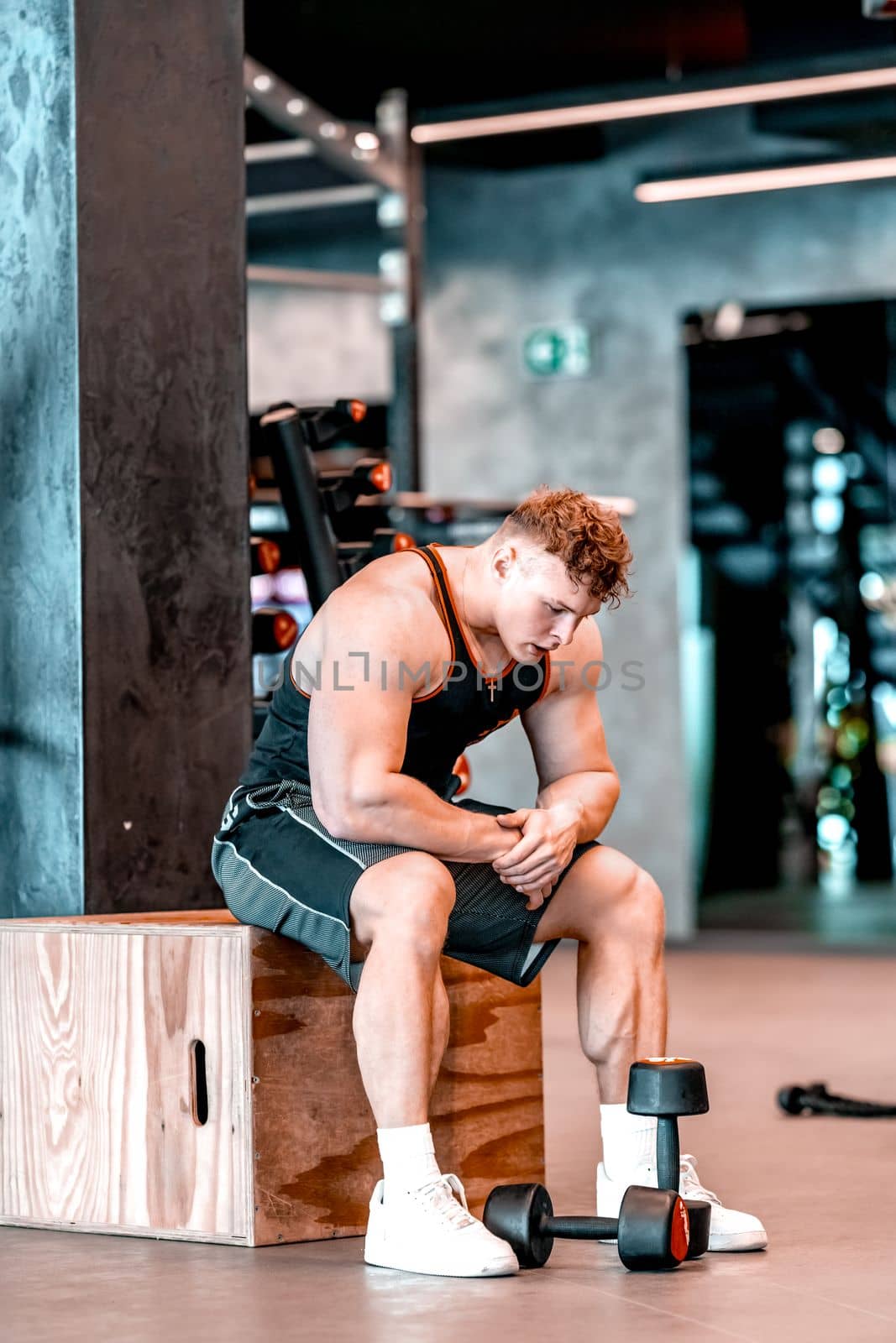 athlete resting in the gym between exercises by Edophoto