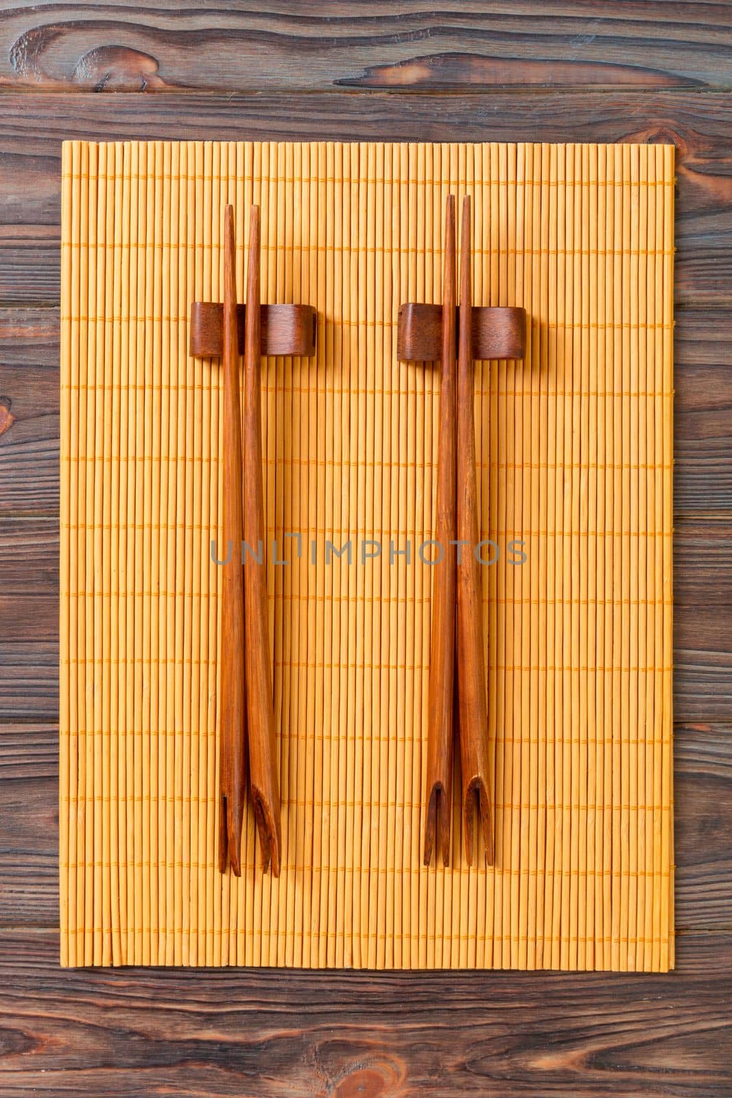two sets of sushi chopsticks on wooden bamboo background, top view.