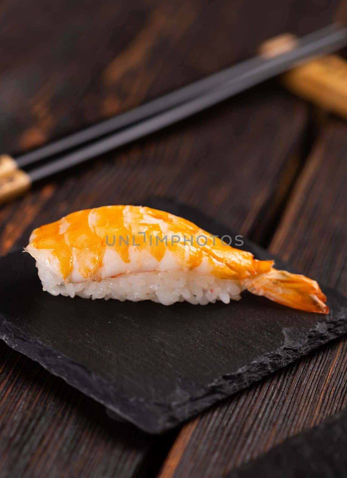 Japanese seafood sushi nigiri with shrimp on black and wooden background - asian cuisine concept by Satura86