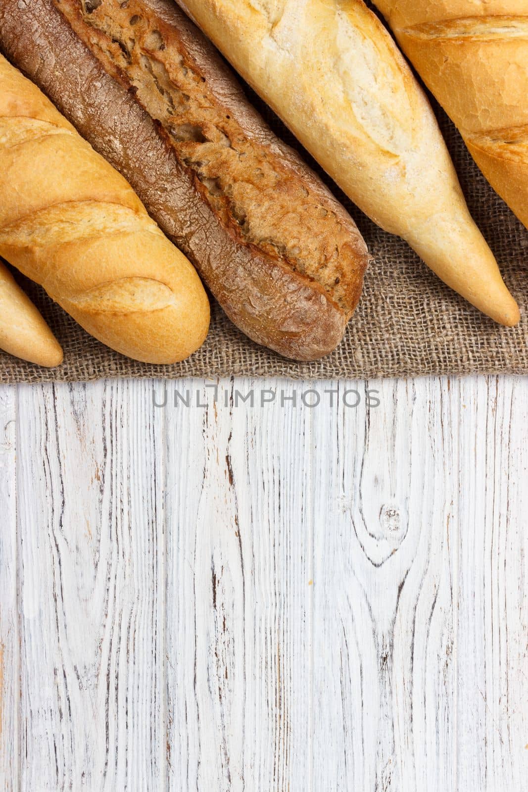 Loaf of bread on a white rustic table. baguette loaf.