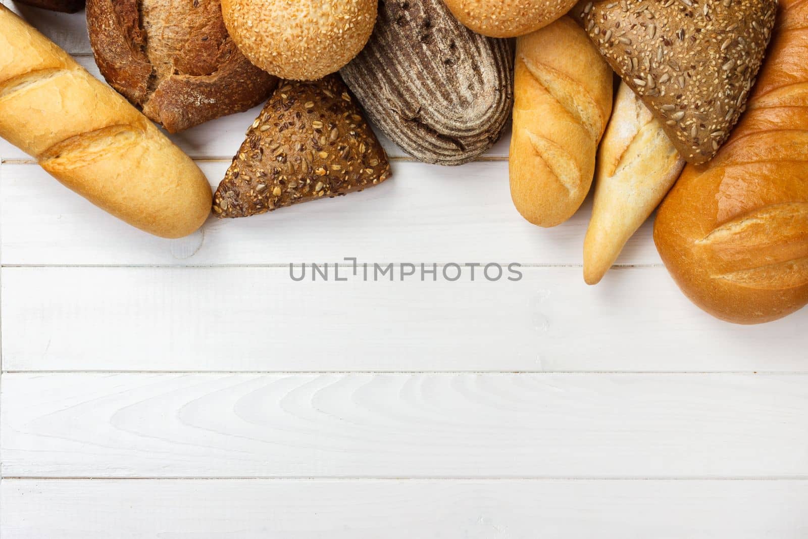 Assortment of baked bread on wooden table background. top view with copy space.