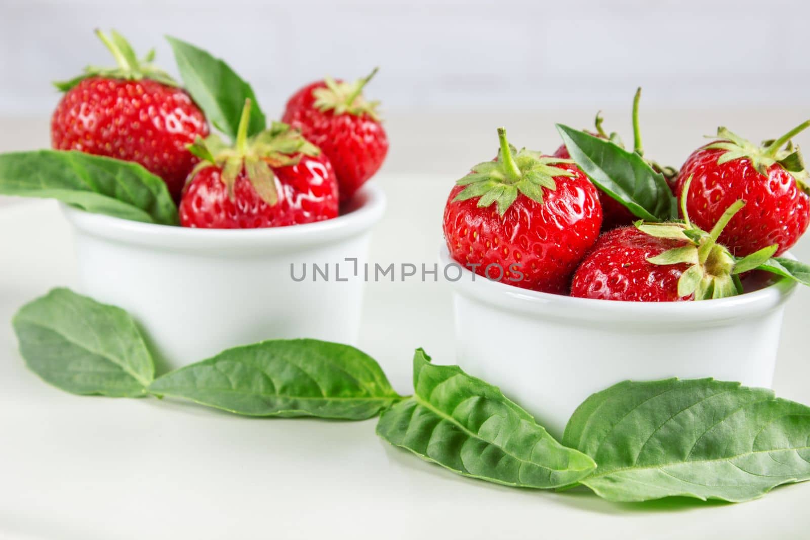 Ripe strawberries anf mint in a bowl on a table