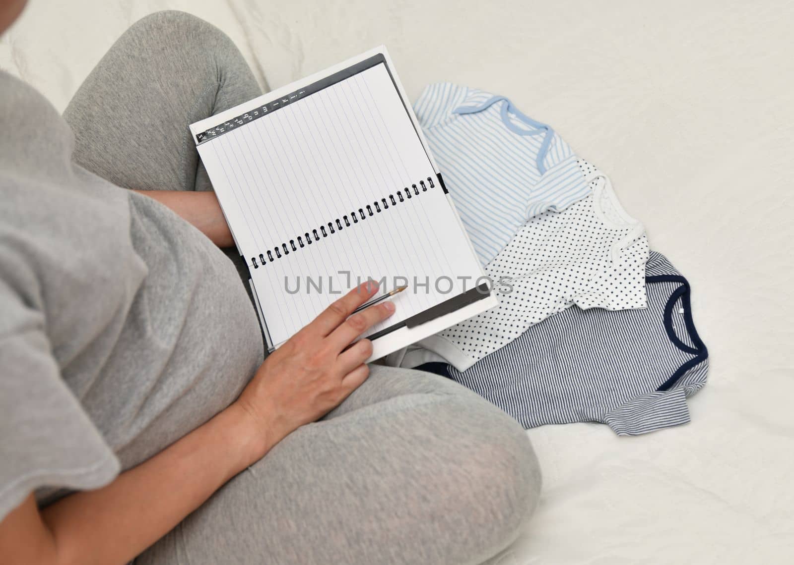 Pregnant woman makes the notes in notebook