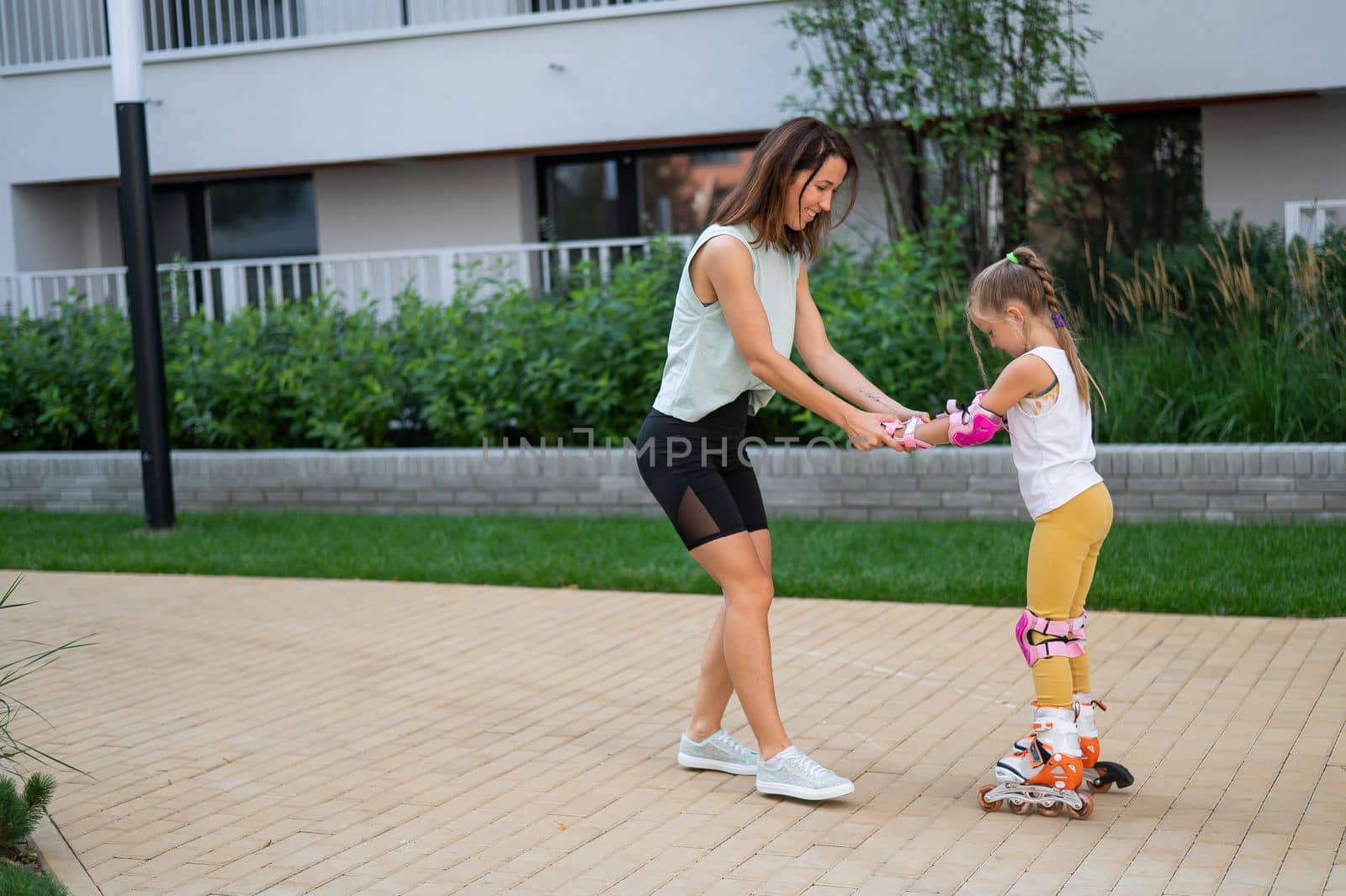 Mother helps daughter learn to roller skate