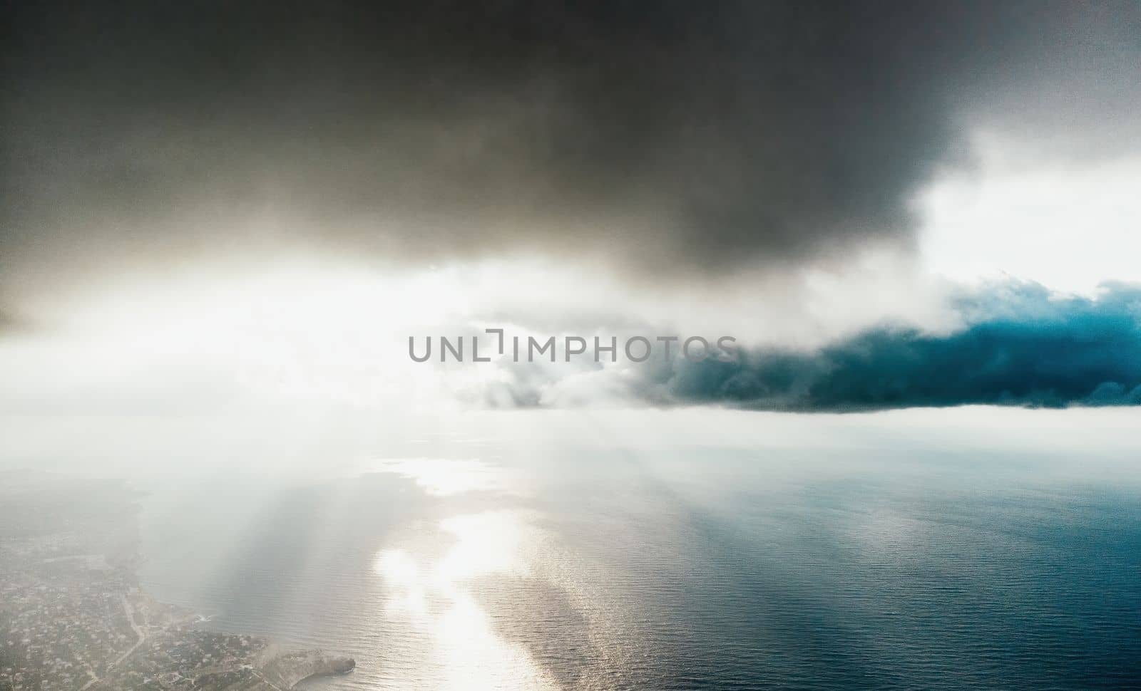 Aerial view. Dramatic sunset over foggy and fluffy clouds. Blue sky sun and sea fog. Abstract aerial nature summer ocean sunset sea and sky background. Horizon. Vacation, travel and holiday concept by panophotograph