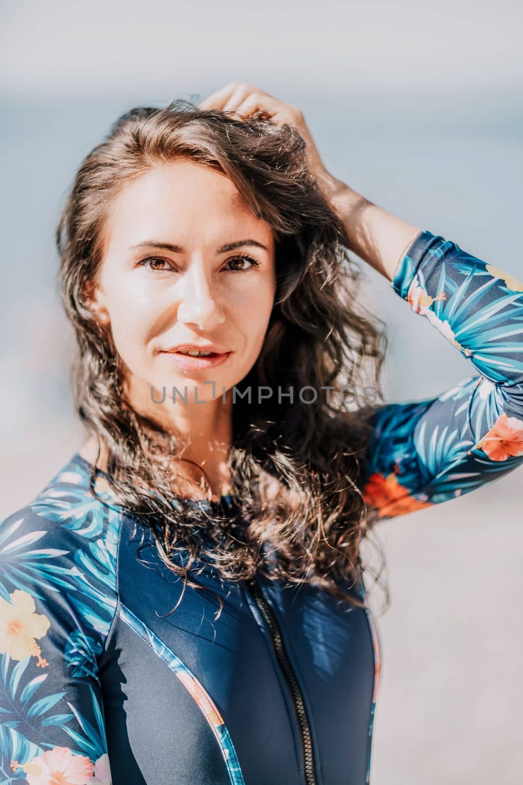 Young woman with black hair, fitness instructor in pink sports leggings and tops, doing pilates on yoga mat with magic pilates ring by the sea on the beach. Female fitness daily yoga concept