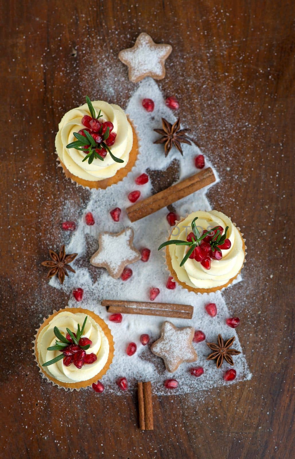 cupcakes with cream decorated with fresh fruits on a wooden