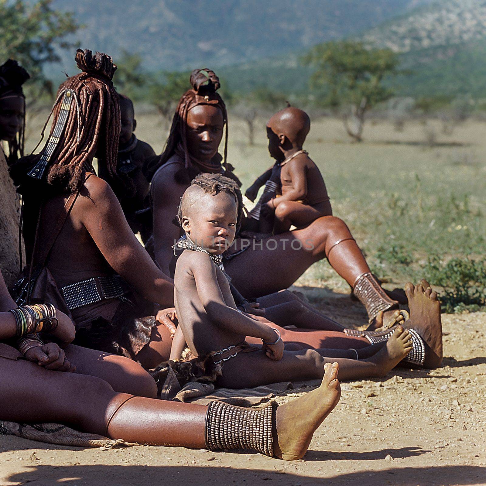 May 15, 2005. Himba women do not identify and their children with traditional hairstyle, necklace and typical ocher skin. Epupa Falls, Kaokoland or Kunene Province, Namibia, Africa