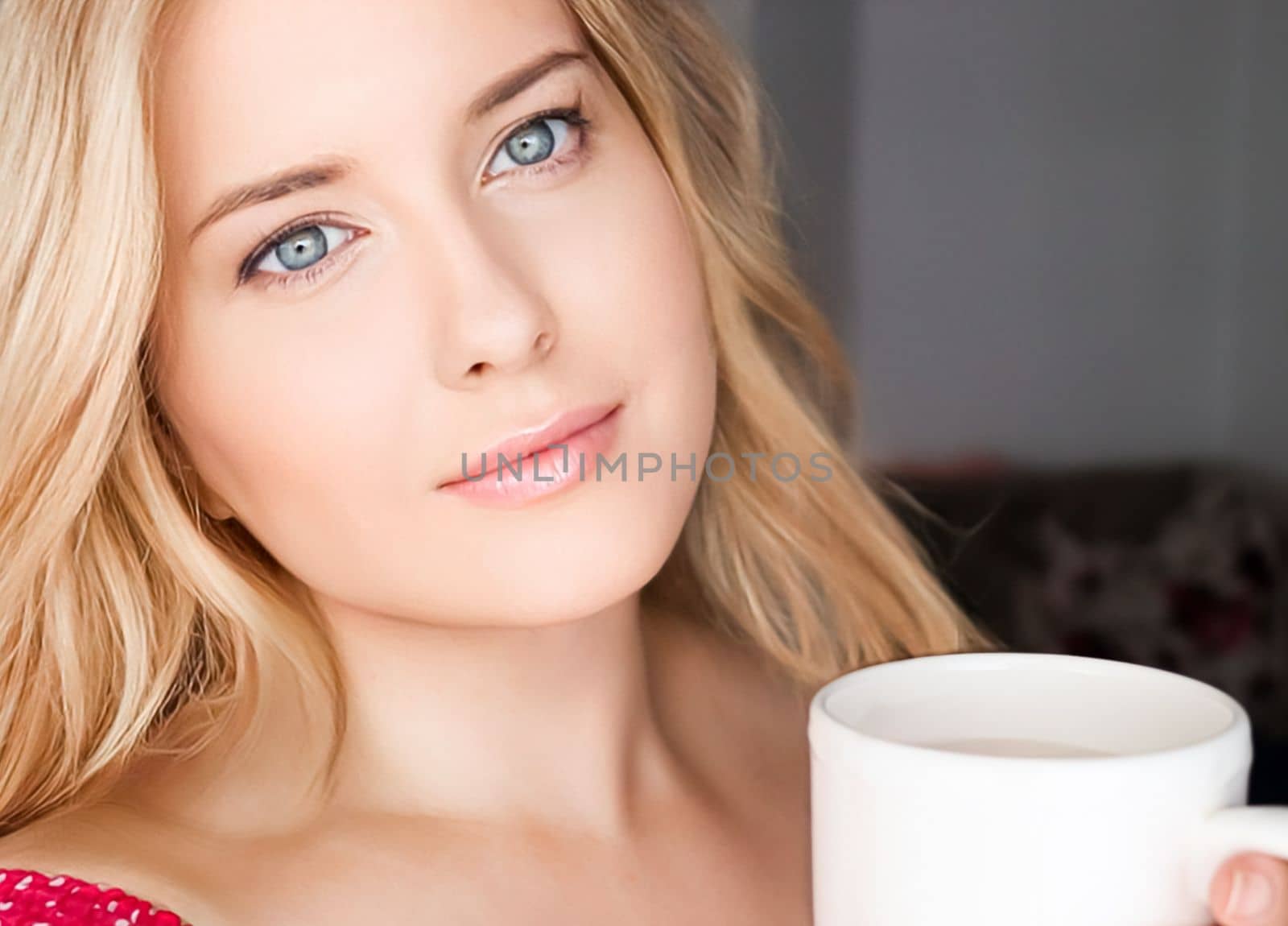 Beautiful blonde woman having a cup of tea in the morning at home.