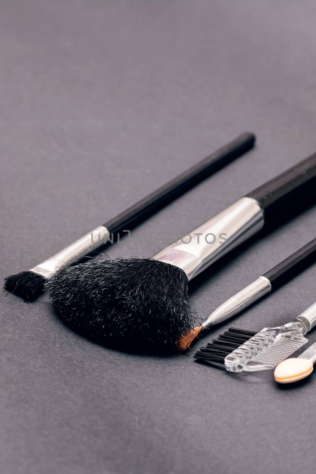Makeup brushes on a purple background close up