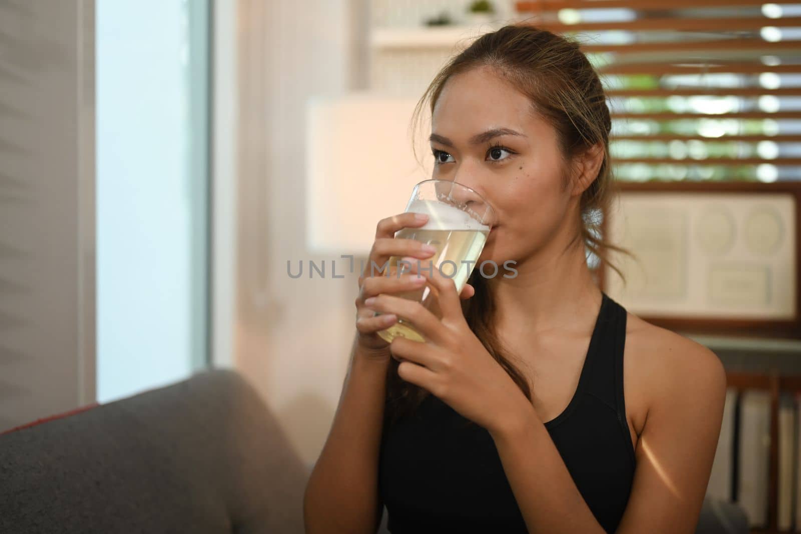 Sporty woman drinking flavored amino acid vitamin powder after exercise. Vitamin, supplement, nutrition, health care by prathanchorruangsak