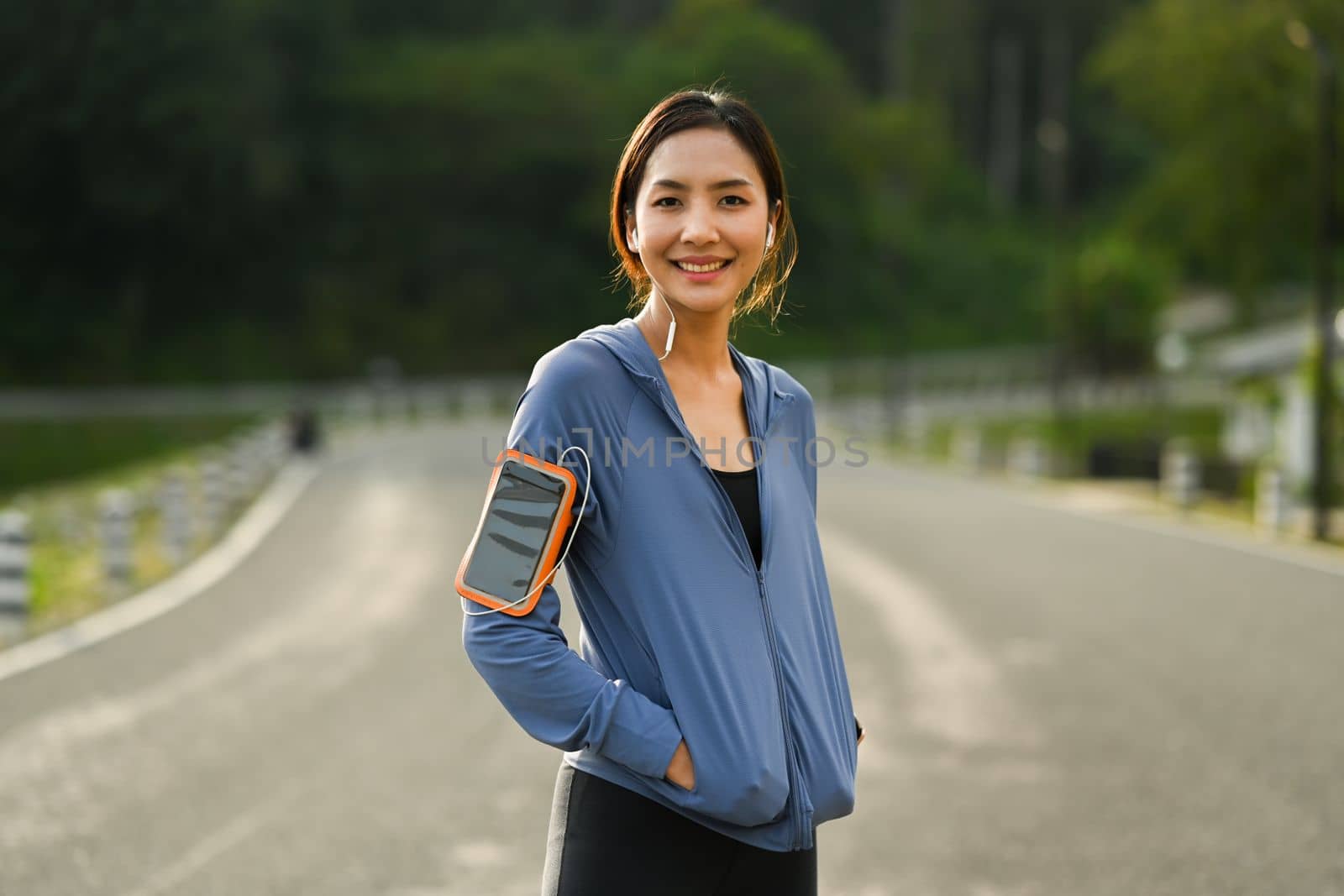 Gorgeous sporty woman taking a break during workout in the park. Healthy lifestyle, workout and wellness concept by prathanchorruangsak