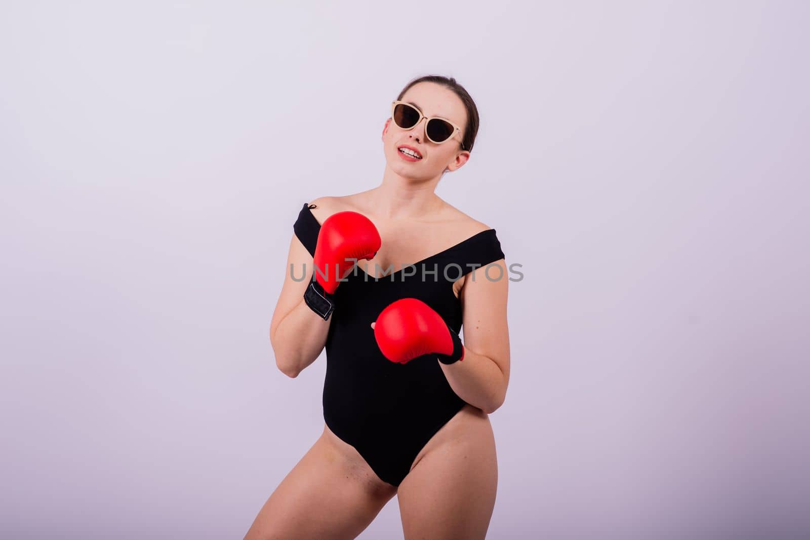 Studio portrait of a boxer female in bodysuit with gloves red